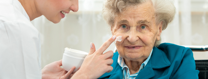 Caregiver applying cream to an older woman's face