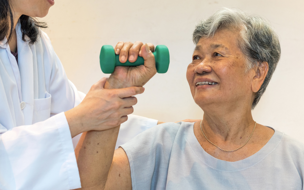 Older woman holding a weight during physical therapy