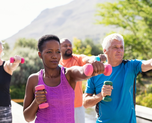 Woman in purple tank top leading a group in exercise